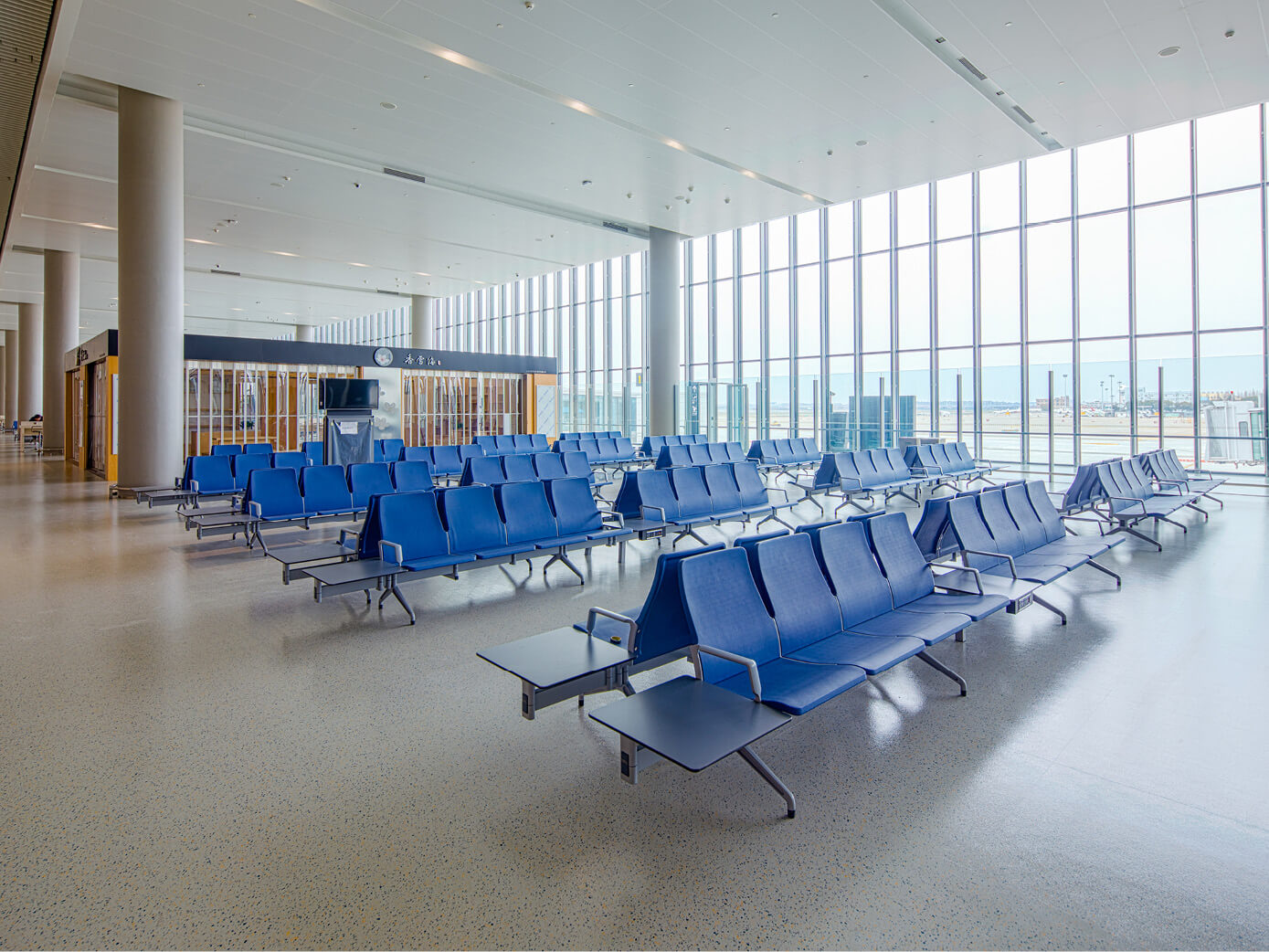 Blue airport bench seats in terminal waiting area